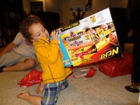 DSC00571  Birthday celebration:  Aidan looks at his new NERF gun, thinking of the ways in which he can use it against his brother.  :) : From MobileMe